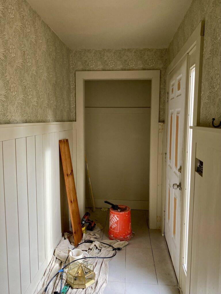 In progress photo of the entryway to the Cabbage with wainscoting and wallpaper.