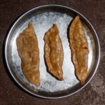 three browned dumplings in pan