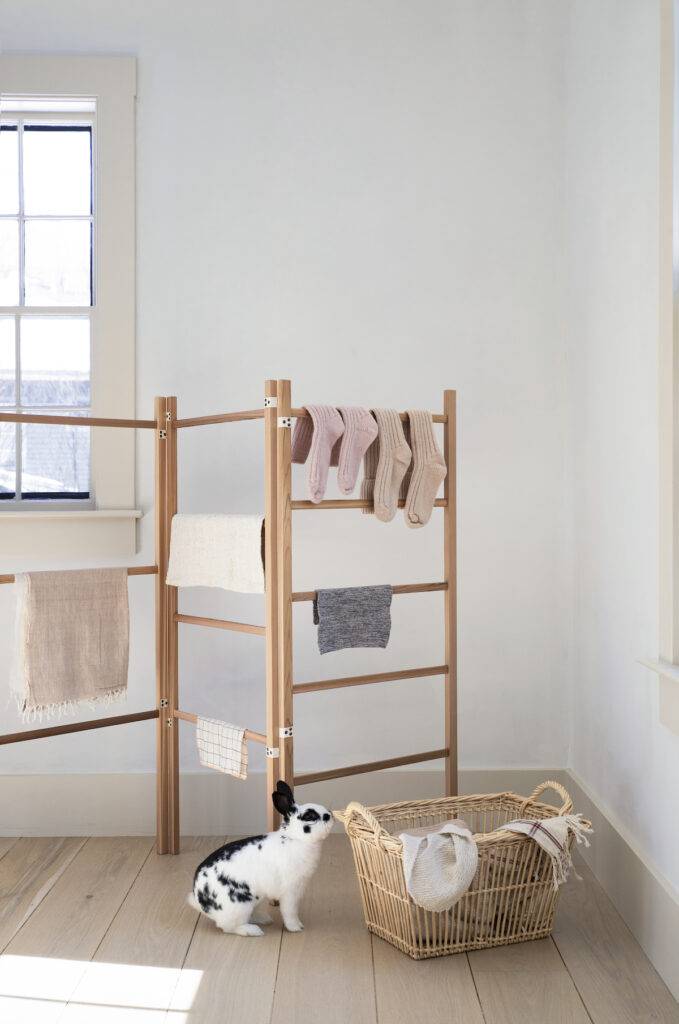 Simple space-saving drying rack from deVOL paired with a vintage basket hamper. — Photo by Justine Hand