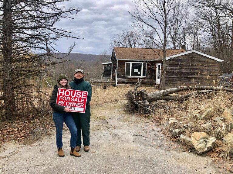 Bea Copeland stands in front of her newly purchased home holding the 