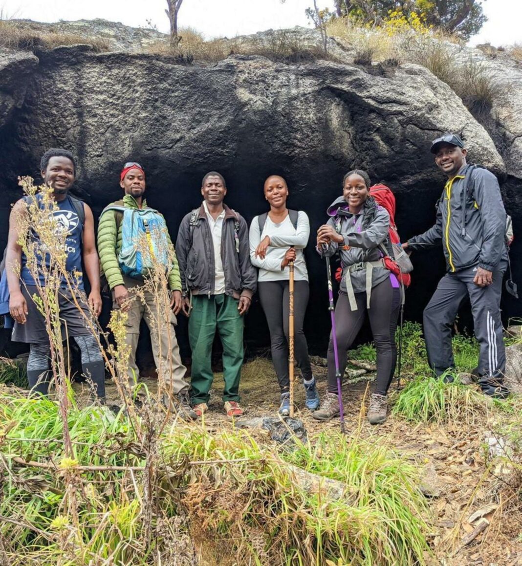 hikers posing by a large rock