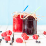 Red and purple drinks in mason jars.