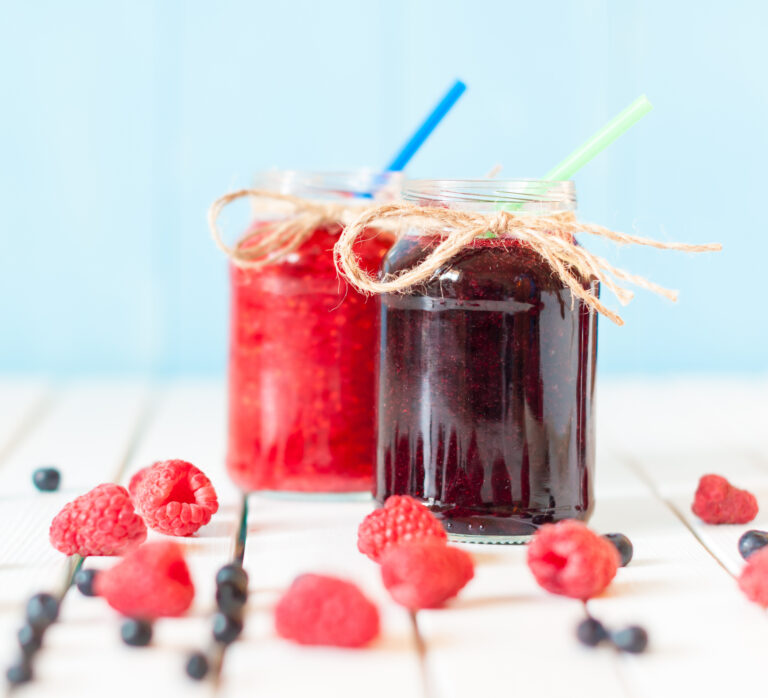 Red and purple drinks in mason jars.